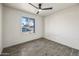 Bright bedroom features a ceiling fan, wood-look tile floors and a large window with views of the neighborhood at 1911 W Kimberly Way, Phoenix, AZ 85027