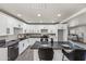 The renovated kitchen showcases sleek, white cabinetry, dark hardware, granite countertops, and modern stainless steel appliances at 1911 W Kimberly Way, Phoenix, AZ 85027