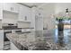 A kitchen with a granite island top, modern oven, white cabinets, and stainless steel appliances at 1911 W Kimberly Way, Phoenix, AZ 85027