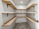 Walk-in pantry featuring wood shelving with black metal supports and neutral-colored flooring at 1911 W Kimberly Way, Phoenix, AZ 85027