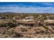 Aerial view of a southwestern home, showcasing the extended patio and desert landscaping, surrounded by a private community at 19131 E Tonto Verde Dr, Rio Verde, AZ 85263