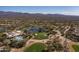 Aerial view of a golf community with lush green courses, a clubhouse with a pool, and scenic mountain views at 19131 E Tonto Verde Dr, Rio Verde, AZ 85263