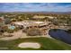 Panoramic view of a community clubhouse with an inviting pool, pond, and a meticulously maintained golf course at 19131 E Tonto Verde Dr, Rio Verde, AZ 85263