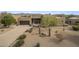 Exterior shot of a desert home with a front yard featuring native landscaping and a circular driveway at 19131 E Tonto Verde Dr, Rio Verde, AZ 85263