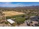 Aerial shot of a golf course with practice facilities, and a view of the surrounding golf cart parking area at 19131 E Tonto Verde Dr, Rio Verde, AZ 85263