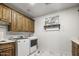 Charming laundry room with wooden cabinetry, white countertops, a sink and modern appliances at 19131 E Tonto Verde Dr, Rio Verde, AZ 85263