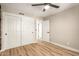 Neutral-toned bedroom featuring hardwood floors, a ceiling fan, and a double closet with white doors at 19409 N 45Th Dr, Glendale, AZ 85308