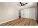 Large bedroom with hardwood floors, a ceiling fan, and a double closet with white doors at 19409 N 45Th Dr, Glendale, AZ 85308