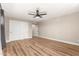 Large bedroom with hardwood floors, a ceiling fan, and closet space with white sliding doors at 19409 N 45Th Dr, Glendale, AZ 85308