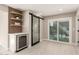 Dining area features a beverage fridge, floating shelves, and glass slider doors for indoor/outdoor entertaining at 19409 N 45Th Dr, Glendale, AZ 85308