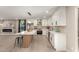 Modern kitchen with white cabinets, stainless appliances, stylish island seating, and a decorative fireplace accent wall at 19409 N 45Th Dr, Glendale, AZ 85308