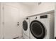 Laundry room with white washer and dryer, shelf, and a white door at 19409 N 45Th Dr, Glendale, AZ 85308