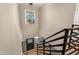 Modern staircase with black metal railing, wood treads, a modern light fixture, and a view of the front door at 19409 N 45Th Dr, Glendale, AZ 85308