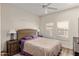 Bright bedroom with a wicker headboard, ceiling fan, plantation shutters and wood flooring at 19700 N 76Th St # 1061, Scottsdale, AZ 85255