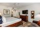 Bright bedroom featuring wood-framed bed, wood floor, wooden dresser, mirror, and sofa at 19700 N 76Th St # 1061, Scottsdale, AZ 85255