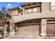 Beige stucco home featuring a two-car garage with matching beige doors and decorative architectural details at 19700 N 76Th St # 1061, Scottsdale, AZ 85255