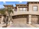 Beige stucco home featuring a two-car garage with matching beige doors and decorative architectural details at 19700 N 76Th St # 1061, Scottsdale, AZ 85255