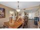 Bright dining room featuring a large wooden table set for a meal, with views to the kitchen and living areas at 20639 N 123Rd Dr, Sun City West, AZ 85375