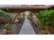 Inviting front entrance with an arched iron gate, desert landscaping, and a smooth walkway for enhanced curb appeal at 20639 N 123Rd Dr, Sun City West, AZ 85375