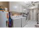 Functional laundry room with white appliances, ample storage cabinets, and tile flooring at 20639 N 123Rd Dr, Sun City West, AZ 85375