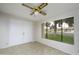 Bright bedroom features a ceiling fan, tiled floors, and a large window with neighborhood views at 2064 S Farnsworth Dr # 43, Mesa, AZ 85209