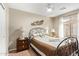 Bedroom with iron bed frame with neutral paint and a bright window with long white drapes at 2101 S Meridian Rd # 176, Apache Junction, AZ 85120