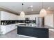 A modern kitchen featuring white cabinetry, black backsplash, granite countertops, and stainless steel appliances at 22465 E Via Del Verde --, Queen Creek, AZ 85142