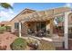 Serene covered patio with outdoor seating, perfect for relaxing and entertaining in your backyard at 22524 N San Ramon Dr, Sun City West, AZ 85375