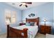 This cozy bedroom boasts soft blue walls, a ceiling fan, and a window with plantation shutters at 22524 N San Ramon Dr, Sun City West, AZ 85375