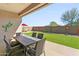 Backyard featuring an extended patio with a dining table and chairs, artificial turf, and desert landscaping at 24847 N 175Th Dr, Surprise, AZ 85387