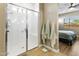 Bathroom featuring a glass-door shower and a view into the primary bedroom at 24847 N 175Th Dr, Surprise, AZ 85387