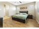 A primary bedroom featuring wood-look floors, a ceiling fan, and a large window for natural light at 24847 N 175Th Dr, Surprise, AZ 85387