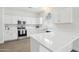 Bright, white kitchen with stainless steel appliances, stone countertops and a view from the arched window at 2502 S 90Th Gln, Tolleson, AZ 85353