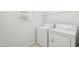 A clean and functional laundry room featuring a washer and dryer with overhead shelving at 2502 S 90Th Gln, Tolleson, AZ 85353