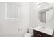 Traditional powder room with a dark wood vanity, round mirror, and window with blinds at 2502 S 90Th Gln, Tolleson, AZ 85353