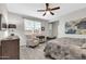 Bright bedroom with a ceiling fan, wood-look floors, a sitting chair, and a sunny window at 256 N Jesse St, Chandler, AZ 85225