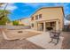 Wide shot of the backyard with patio, firepit, and tan stucco exterior at 28282 N Castle Rock Dr, San Tan Valley, AZ 85143