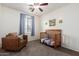 Cozy bedroom with a ceiling fan, crib, accent chair, and charming decor perfect for a room at 28282 N Castle Rock Dr, San Tan Valley, AZ 85143