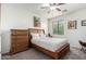 Charming bedroom featuring a wooden bed frame, dresser, and soft lighting, creating a cozy retreat at 28282 N Castle Rock Dr, San Tan Valley, AZ 85143