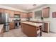 Modern kitchen featuring stainless steel appliances, an island with seating, and tile flooring at 28282 N Castle Rock Dr, San Tan Valley, AZ 85143