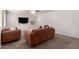 Bright living room featuring a large TV, brown leather sofas, neutral walls, and plush carpeting at 28282 N Castle Rock Dr, San Tan Valley, AZ 85143