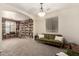 Large living room with a comfortable green sofa and a bookshelf with library ladder; great space to unwind at 28282 N Castle Rock Dr, San Tan Valley, AZ 85143