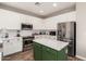 Bright kitchen with stainless steel appliances, white cabinets, subway tile backsplash, and a green island at 32 W Desert Vista Trl, San Tan Valley, AZ 85143