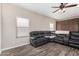 Comfortable living room with a large sectional sofa, ceiling fan, and wood-look tile flooring at 32 W Desert Vista Trl, San Tan Valley, AZ 85143