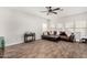 Comfortable living room featuring wood-look tile flooring, fan, and ample natural light at 32 W Desert Vista Trl, San Tan Valley, AZ 85143