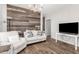 Cozy living room features a decorative wood panel wall, plush seating, and wood-look tile flooring at 32 W Desert Vista Trl, San Tan Valley, AZ 85143