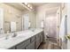 A bathroom with a double sink vanity and a door to a shower at 3603 E Indigo Bay Ct, Gilbert, AZ 85234