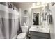 Neat bathroom with a shower-tub combo, single sink vanity, decorative mirror and neutral color palette at 3603 E Indigo Bay Ct, Gilbert, AZ 85234