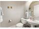 A half bathroom with a pedestal sink, toilet, and decorative wall hangings at 3603 E Indigo Bay Ct, Gilbert, AZ 85234