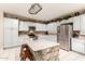 Well-lit kitchen with a center island, white cabinets, tile floors and stainless appliances at 3603 E Indigo Bay Ct, Gilbert, AZ 85234